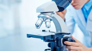 technician looking through microscope